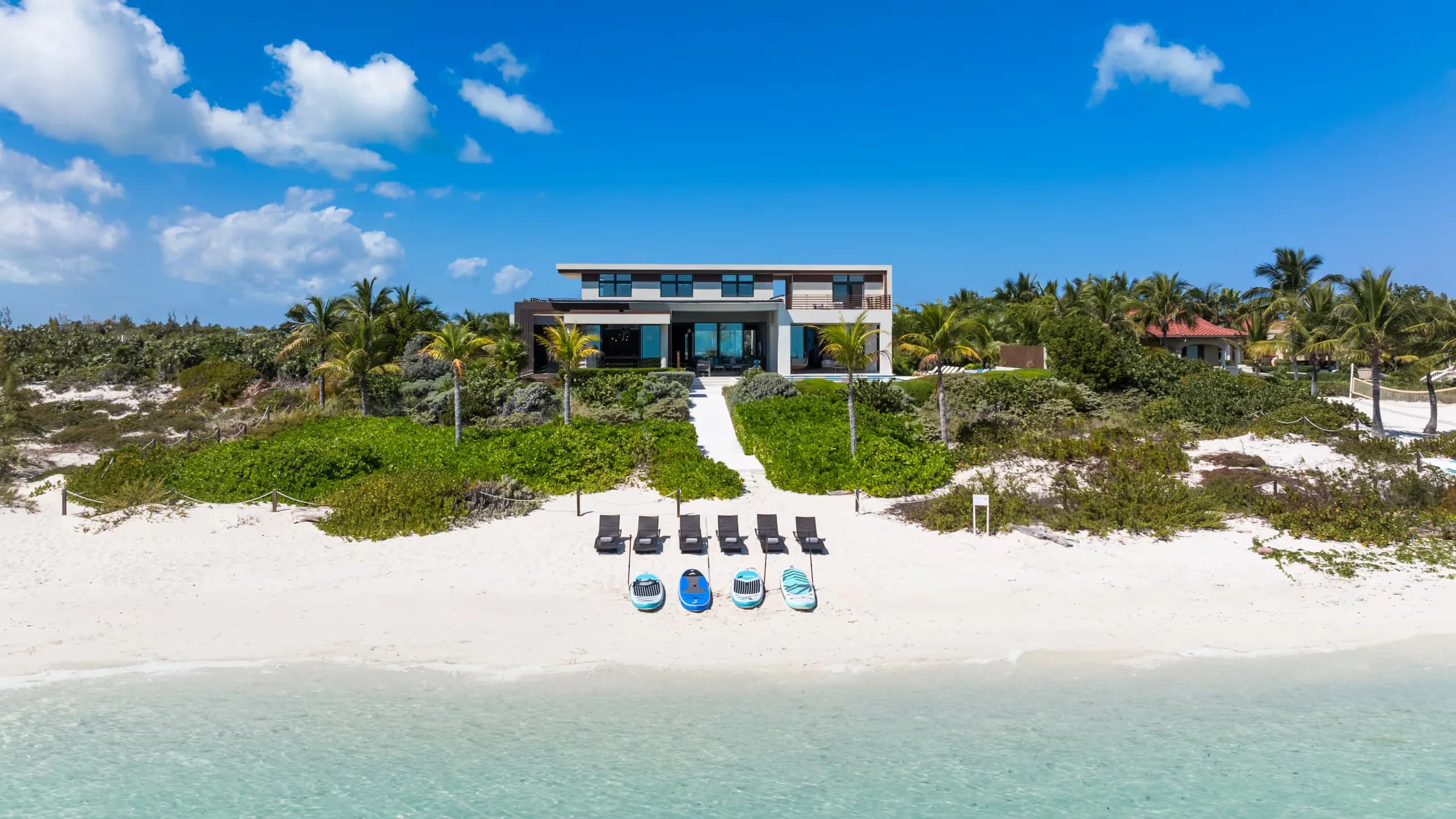 Waterfront luxury vacation villa with pool — the kind of property Housekeeper AI is designed to watch (concept imagery)